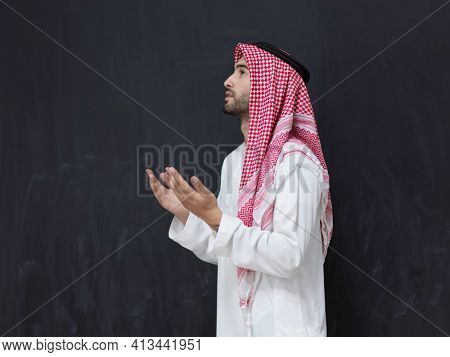 Arab man in traditional clothes praying to God or making dua