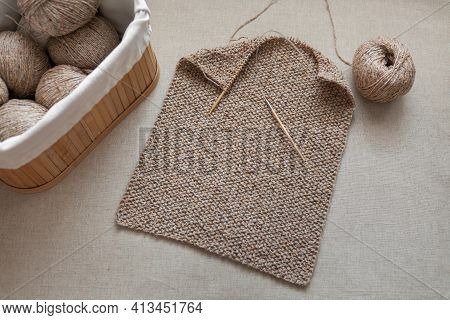 Part Of A Scarf Knitted With Circular Bamboo Needles. Balls Of Wool Yarn In A Basket. Selective Focu