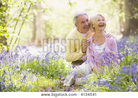 Coppie seduti all'aperto con fiori sorridente