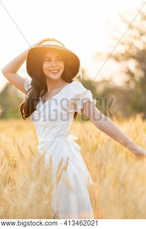 Happy Young Beautiful Woman Wearing Black Hat And White Dress Enjoying Herself Walking In The Golden