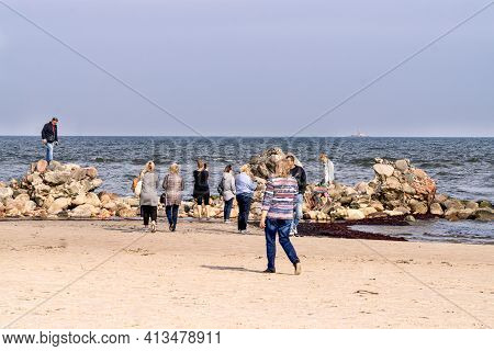 Tourists Take Pictures Of The Lightest Stone Boulders Of The Breakwater On The Coast Of The Gulf Of 