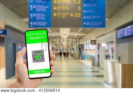 Traveler Hand Hold Phone With Health Passport Of Vaccination Certification. Health Pass On Phone At 