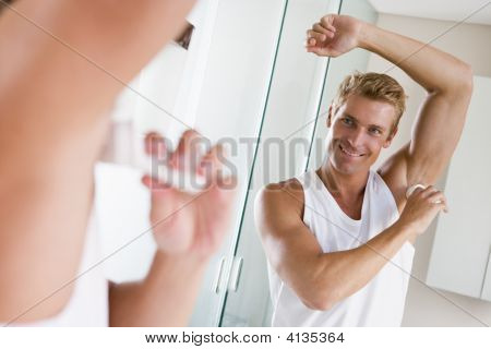 Muž v koupelně použití Deodorant s úsměvem