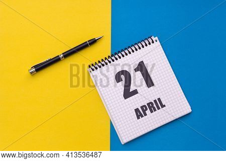 April 21th. Day Of 21 Month, Calendar Date. A Notebook With A Spiral And A Pen Lies On A Yellow-blue