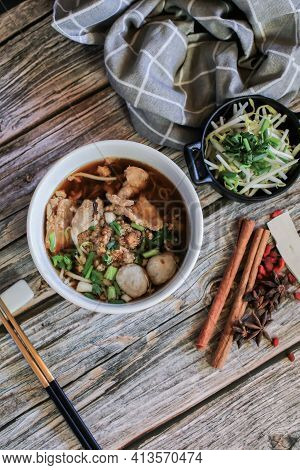 Egg Noodle With Pork And Vegetable In Five Spices Black Soup On Wooden Table Top View
