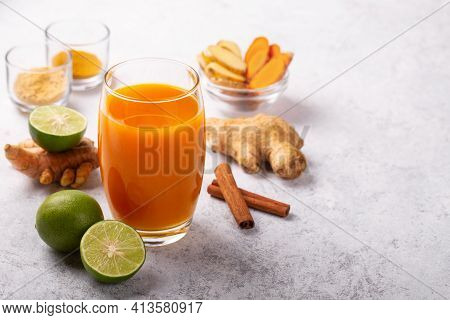 Healthy Drink From Turmeric And Ginger Roots And Lime In A Glass On White Concrete Background With C