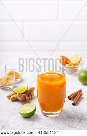 Healthy Drink From Turmeric And Ginger Roots And Lime In A Glass On White Concrete Background With C
