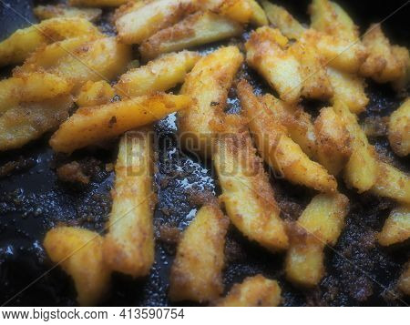 Fried Potatoes Or French Fries With Turmeric, Curry And Bread Crumbs. Close-up. Delicious Side Dish.