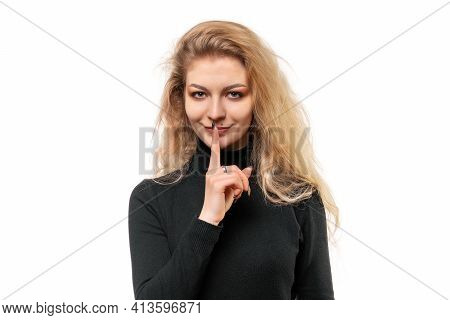 Close Up Portrait Of Blonde Girl Keeping Finger At Her Mouth, Saying Shh, Hush, Tsss. Silence And Se