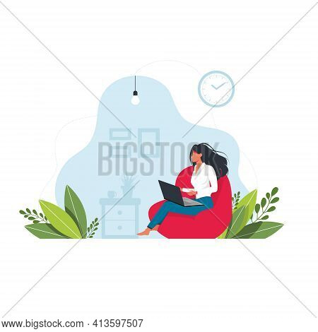 Woman Sits On An Ottoman And Works At A Laptop. Woman With Laptop Sits On A Large Pouf. Concept Of C