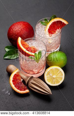 Fresh citrus lemonade with mint and crushed ice. Bood orange, lime, lemon and juicer