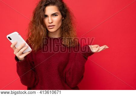 Close Up Photo Of Pretty Serious Adult Woman With Curly Hair Wearing Dark Red Sweater Isolated On Re