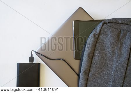 Gray Backpack With Black Tablet And Silver Laptop Or Ultrabook Lies On White Background Next To Larg