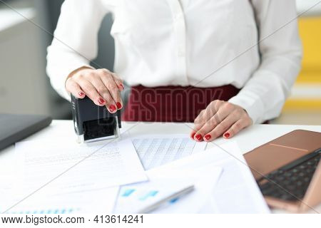 Businesswoman Puts Stamp On Documents On Work Table