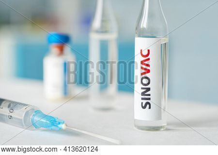 A Bottle Of Vaccine And A Syringe On A White Table On A Blue Background. March 15, 2021. Barnaul, Ru