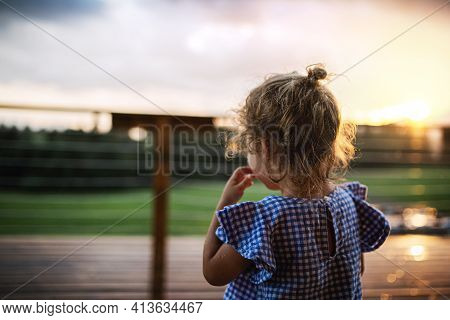 Rear View Of Small Girl Outside At Dusk, Holiday In Nature Concept.