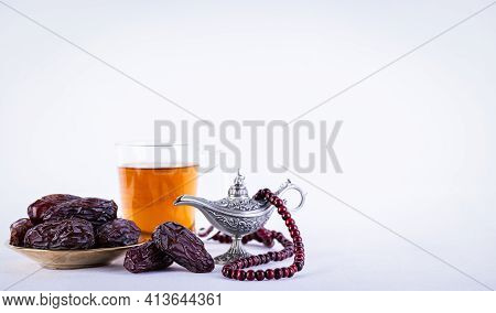 Ramadan Food And Drinks Concept. Ramadan Arabian Lamp, Wood Rosary, Tea, And Dates Fruit On White Ba