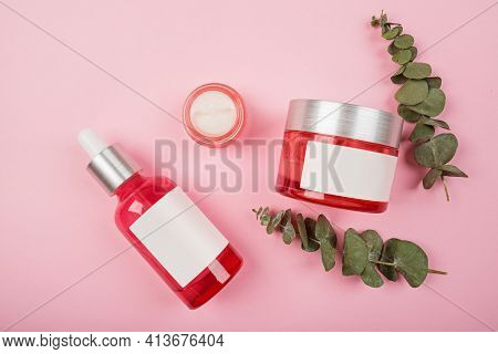 Flat Lay With Natural Organic Cosmetics: Serum, Cream On Pink Background With Green Leaves. Skincare