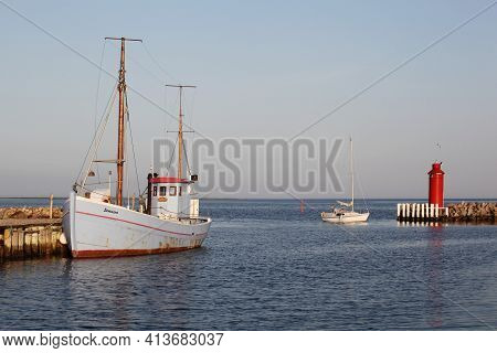 Hou, Denmark - June 10, 2014: The Red Lighthouse Of Hou With A Fisherman's Boat