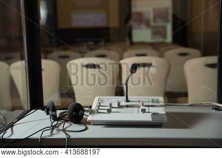 Soft Focus Of Wireless Conference Microphones And Notebook In A Meeting Room. Translators Cubicle . 