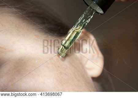 Cropped View Of A Woman Applying Liquid From A Glass Bottle, Skin Texture, Woman Age Forty Plus. By 
