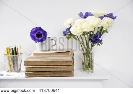 One Blue Anemone In A Cup In The Style Of The Seventies On The Table With Books As An Interior Decor