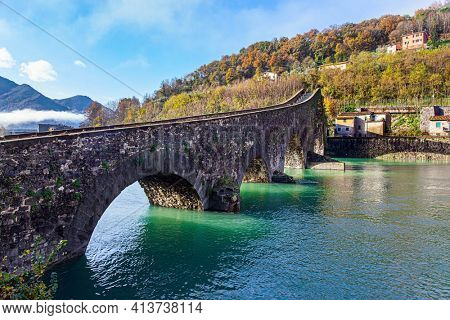 Picturesque stone bridge built a thousand years ago. Devil's Bridge over the Sercchio River. Cold windy winter day. Travel to fabulous Italy. 