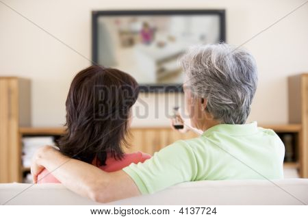 Casais assistindo televisão com controle remoto