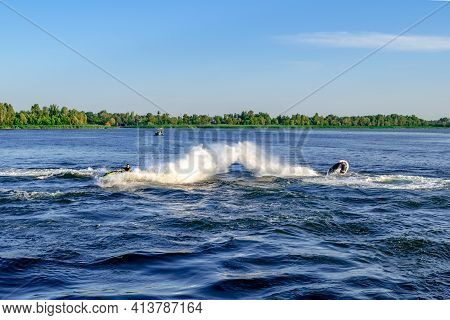 Two Sportsmen Have Fun On Water Scooters On The Dnieper River In Kherson (ukraine). Men On Pwcs Put 