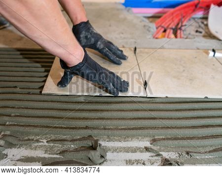 Skilled Worker Installing The Ceramic Tiles On The Floor Worker Making Flooring On The Construction 