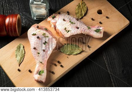 Chicken Legs On A Cutting Board With Spices. The Idea To Cook Lunch Or Breakfast In A Street Cafe. V