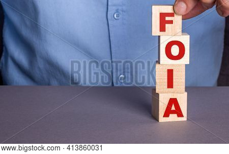 A Man In A Blue Shirt Composes The Word Foia The Freedom Of Information Act From Wooden Cubes Vertic