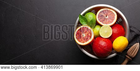 Various fresh citrus fruits in colander. Bood orange, lime, lemon. Top view flat lay with copy space