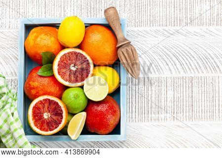 Various fresh citrus fruits in wooden box. Bood orange, lime, lemon. Top view flat lay with copy space