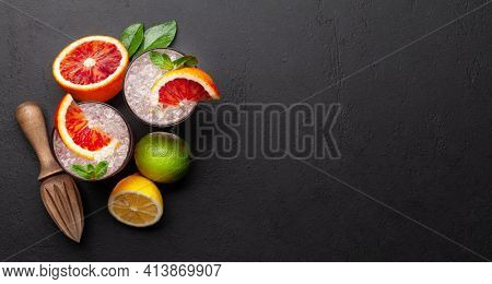 Fresh citrus lemonade with mint and crushed ice. Bood orange, lime, lemon and juicer. Top view flat lay with copy space