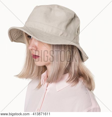 Teenage girl in beige bucket hat for street fashion shoot