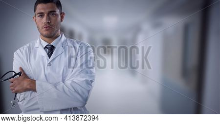 Portrait of caucasian male doctor with arms crossed standing at hospital. healthcare and professionalism concept standing