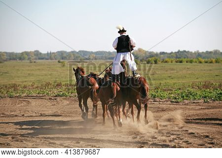 Puszta, Hungary, September, 04. 2020: Hungarian Csikos In Traditional Folk Costume Showing His Train