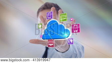 Composition of digital blue cloud with network of digital icons over hand of businessman. global technology and digital interface concept digitally generated image.