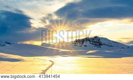 Scenic Sunset View Over A Mountain Highland Covered In Snow And Ice On A Cold Winters Day.