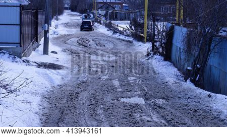 Maykop, Adygea Republic, Russia - March 13, 2021: Poor Spring Road In Pits And Puddles From Melting 