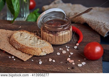 Handmade Chicken Pate In A Glass Jar On A Wooden Board .
