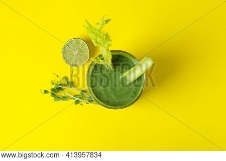 Glass Of Green Smoothie And Ingredients On Yellow Table