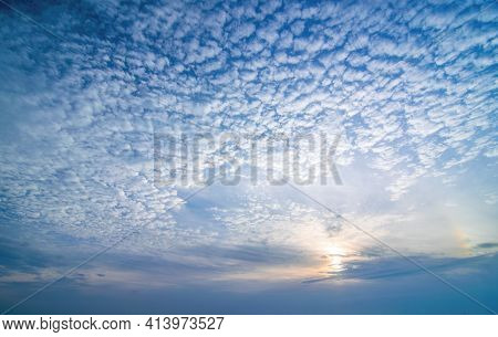 Sky Background With Low Sun And Cirrocumulus Clouds