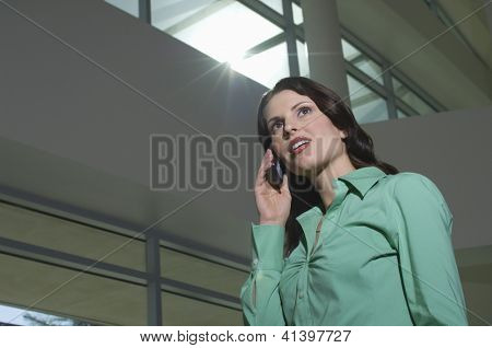 Lage hoek weergave van een zakenvrouw met gesprek op mobiele telefoon terwijl looking away