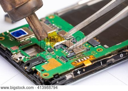 Close-up Of Electronics Repairs. Electronics Repair Soldering Of Microchips And Printed Circuit Boar