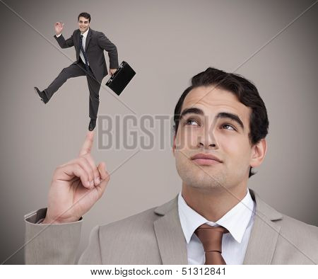 Businessman showing shrunk colleague with his briefcase dancing on his finger