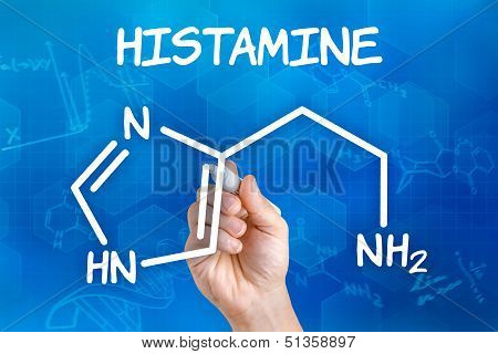 Hand with pen drawing the chemical formula of histamine