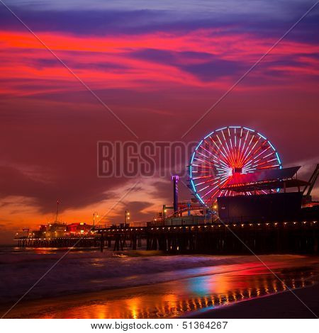Santa Monica California sunset on Pier Ferris wheel and reflection on beach wet sand