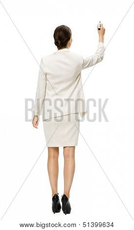 Full-length backview of businesswoman writing on imaginary screen with marker, isolated on white. Concept of leadership and success